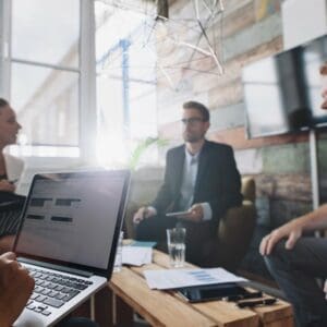 Group working in a business meeting with Apple laptop