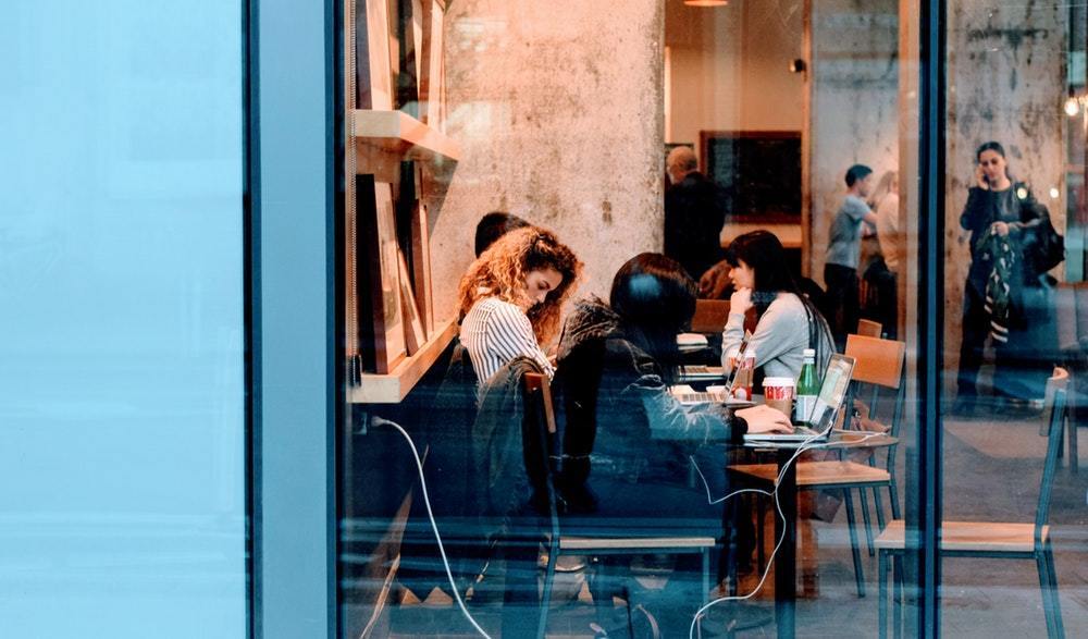 People working on laptops in a crowded café
