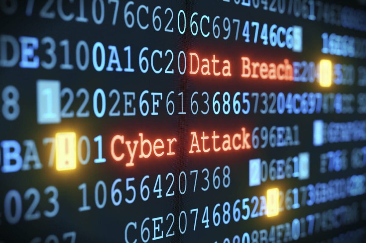 cyber-attack-data-breach Graphic of blue computer code on a black screen with the words Data Breach and Cyber attack in red.