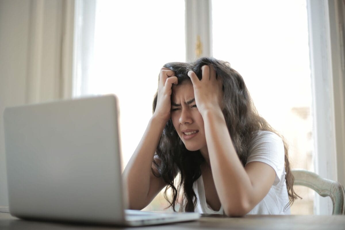 Frustrated young lady working from home on an Apple laptop